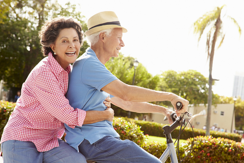 Elderly couple riding a bike together